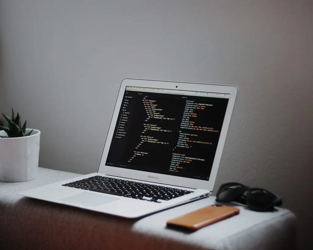 Laptop on a desk showing a code editor