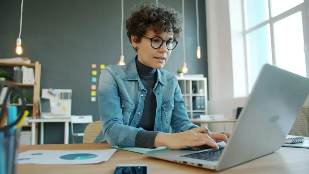 Woman working on a laptop at a desk in a modern office